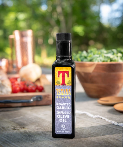 Image of Texana Brands garlic infused olive oil on outside picnic table