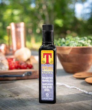 Image of Texana Brands garlic infused olive oil on outside picnic table 